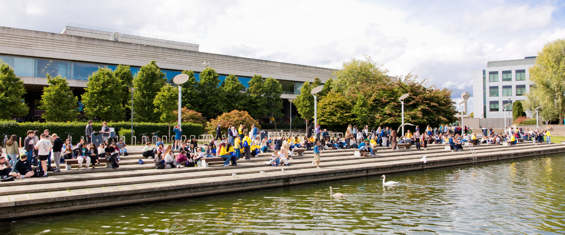 Image of students seating on the stairs around the main lake on UCD Belfield Campus